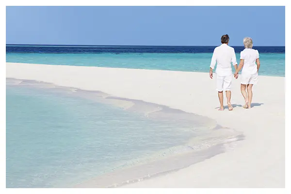 砂浜を歩く夫婦