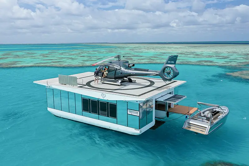 海に浮かぶ「ハートアイランド・ポンツーン」のヘリパッドに着陸するヘリコプター